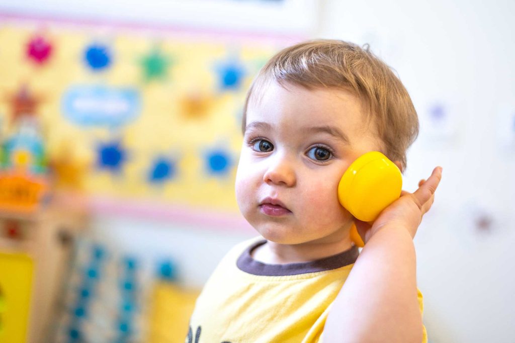 Toddler playing on a toy phone