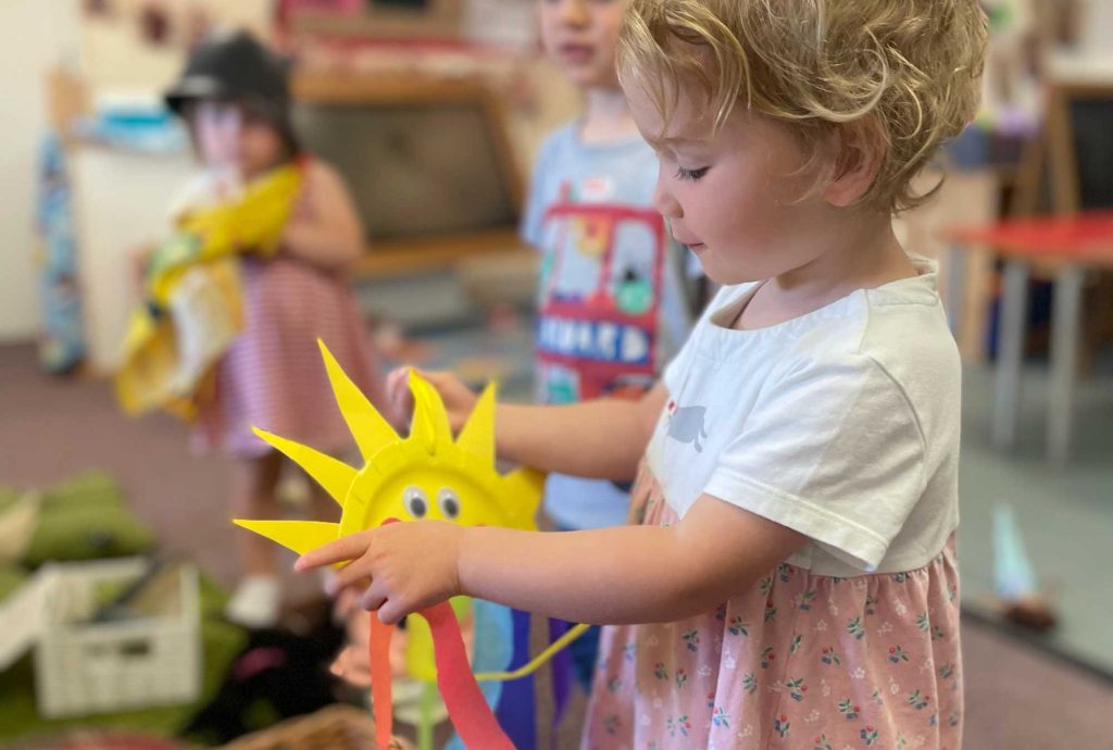 Child holding sunshine craft